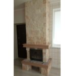 Kominek jest wyłożony kamieniem naturalnym, drewnem i płytkami ceramicznymi.