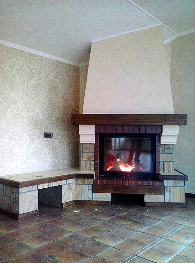 Kominek jest wyłożony kamieniem naturalnym, drewnem i płytkami ceramicznymi.