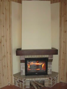 Kominek jest wyłożony kamieniem naturalnym, drewnem i płytkami ceramicznymi.