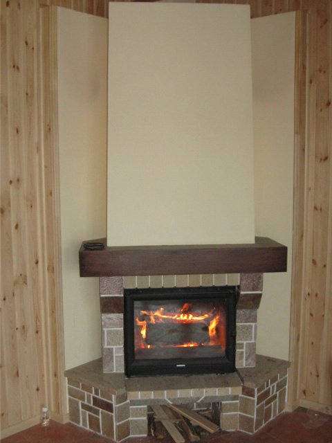 Kominek jest wyłożony kamieniem naturalnym, drewnem i płytkami ceramicznymi.