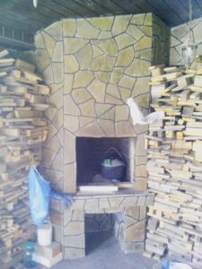 Grill ogrodowy wyłożony jest kamieniem naturalnym, płytkami ceramicznymi 