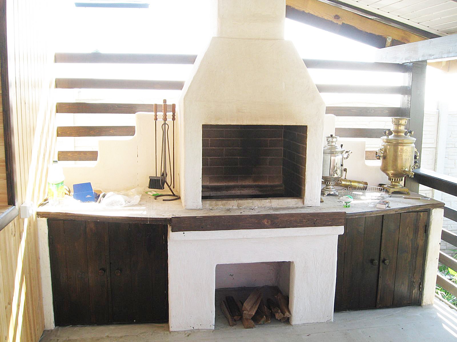 Grill ogrodowy jest otynkowany i pomalowany. Zawiera dekoracyjne elementy drewniane.