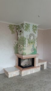 kominek wyłożony naturalnym kamieniem i pomalowany artystycznymi malowidłami ściennymi