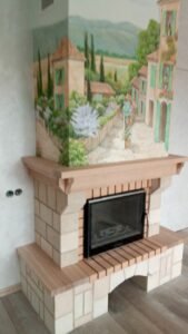 kominek wyłożony naturalnym kamieniem i pomalowany artystycznymi malowidłami ściennymi